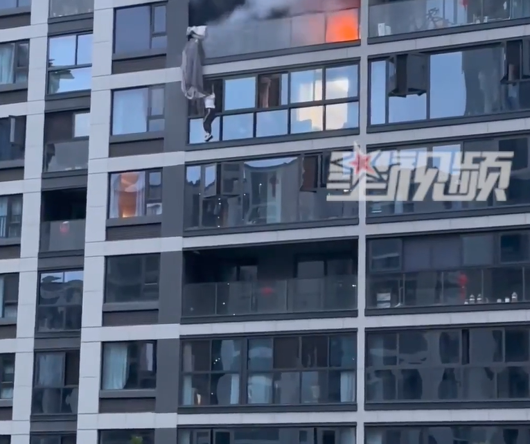 杭州大火住客露台逃生,初時仍未墮樓。(網上截圖)
