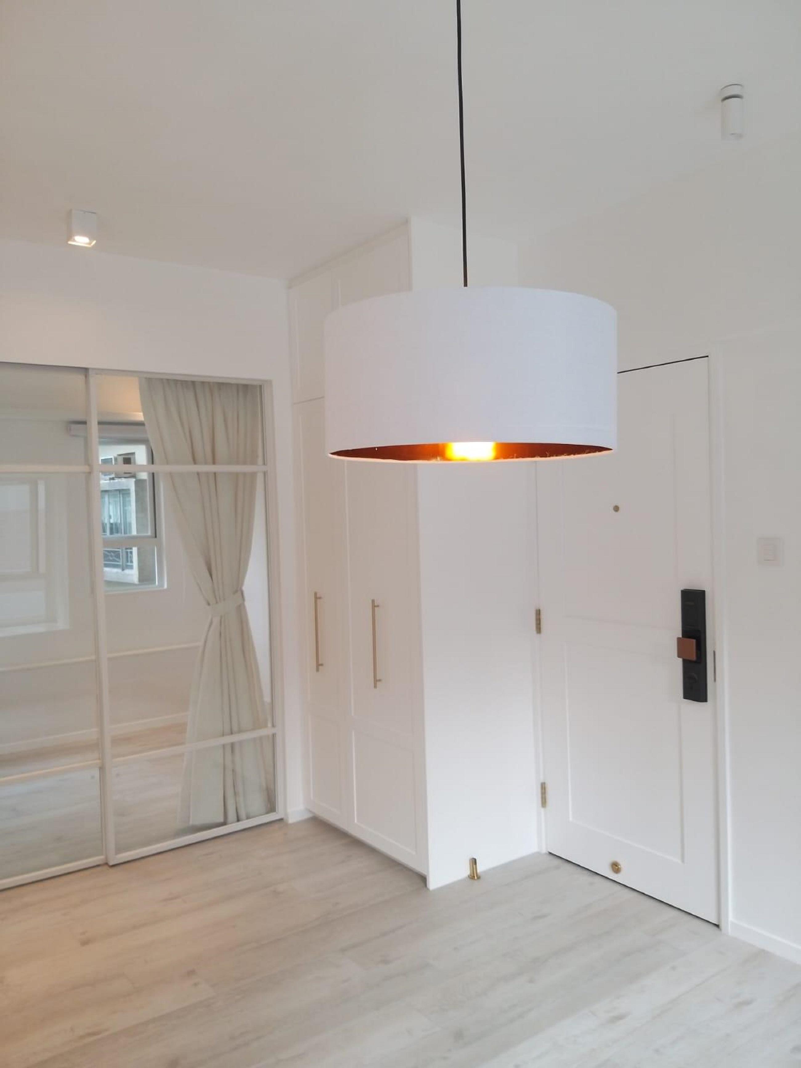 大門的玄關位不大,旁邊設有訂製白色鞋櫃,設計實用又典雅。