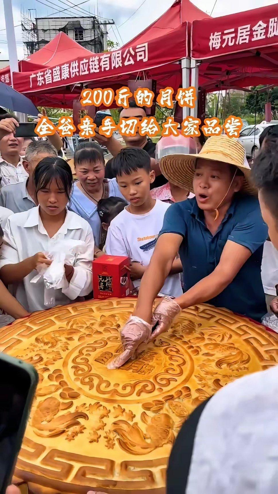 9月17日中秋節,全紅嬋的父親全文茂(右戴帽者)邀請遊客和鄉親免費品嚐巨型月餅。(微博圖片)