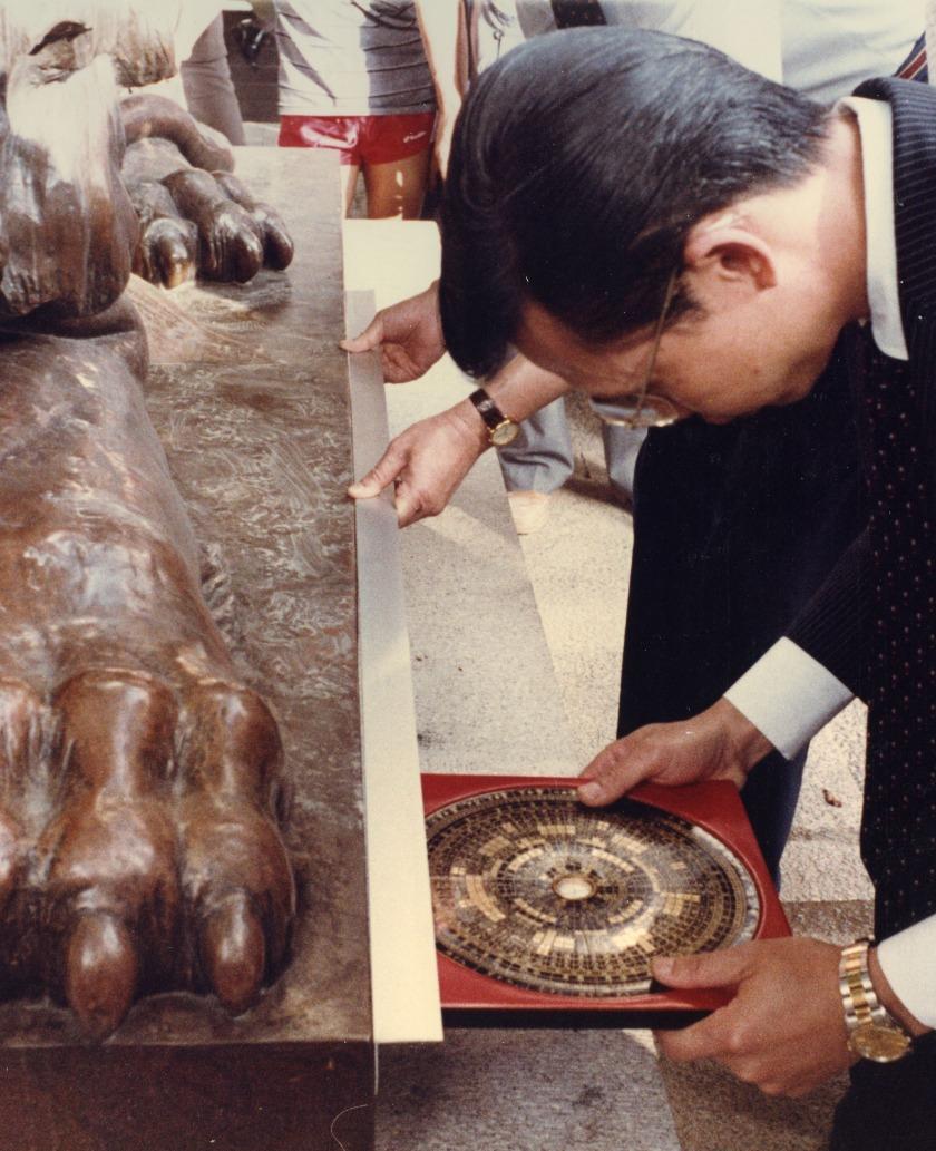 1980年代滙豐把第三代的舊總行拆卸,興建新大樓,銅獅被安置於馬路對面的皇后像廣場,為免破壞滙豐的風水格局,搬運過程由風水大師龍景銓全程監督。(圖片來源:滙豐銀行官網)