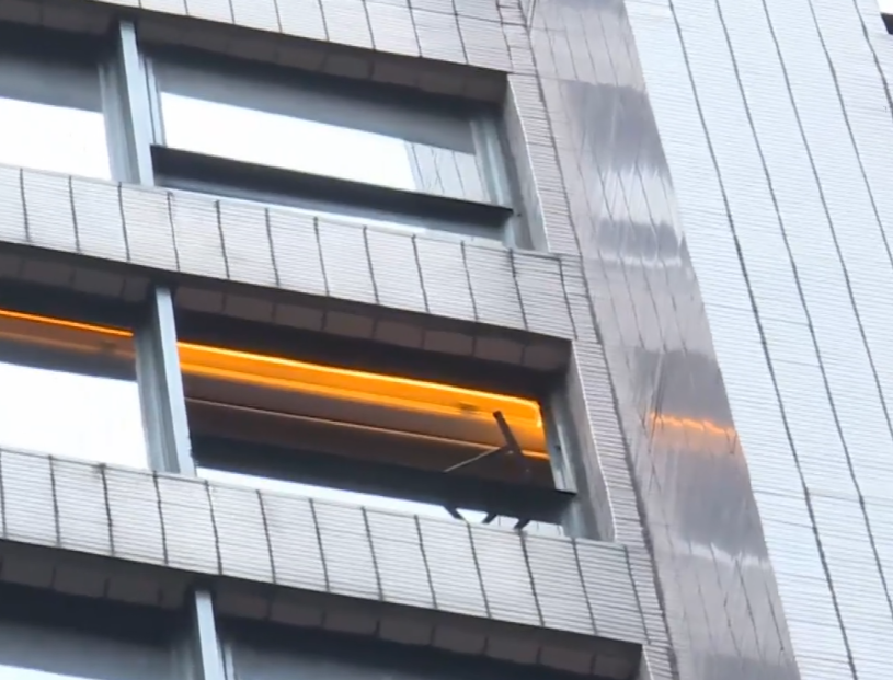 中環士丹利街50號一幢商業大廈有鋁窗從高處墜下,3輛私家車及一名女途人被碎片濺中,女子手傷經救護員治理後毋須送院。(有線新聞畫面)