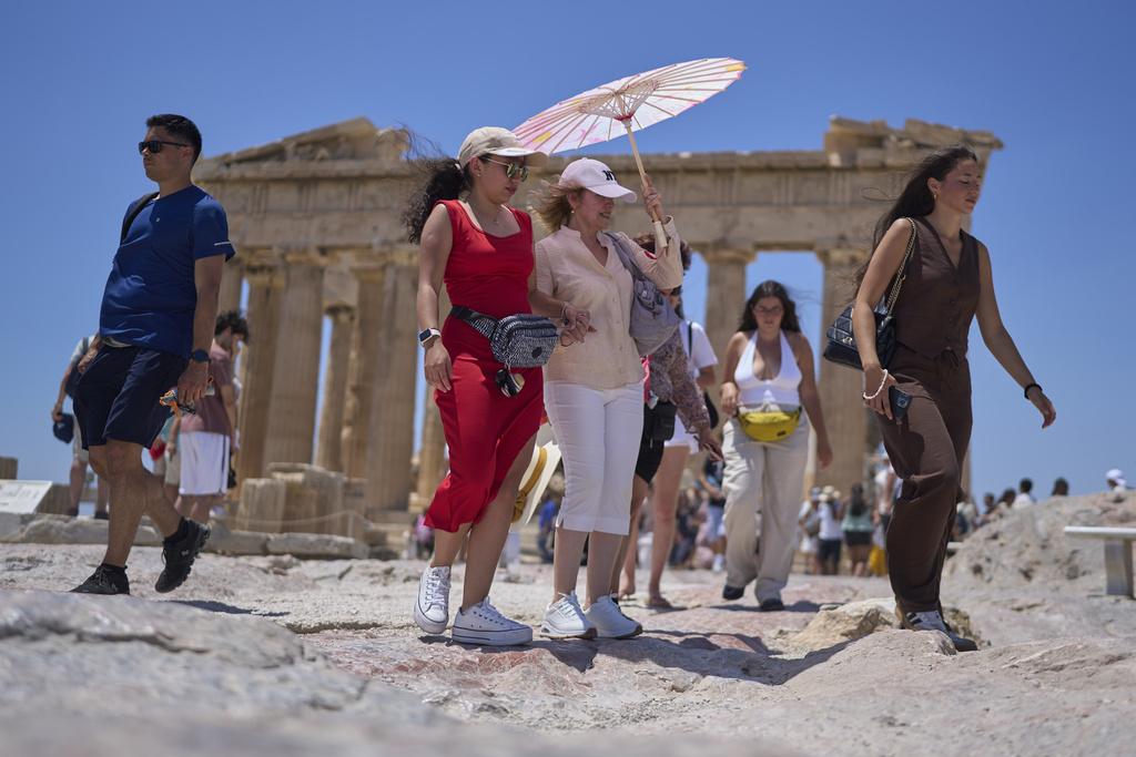 希臘旅遊勝地雅典衛城陽光猛烈,有遊客撐傘降溫。(美聯社)