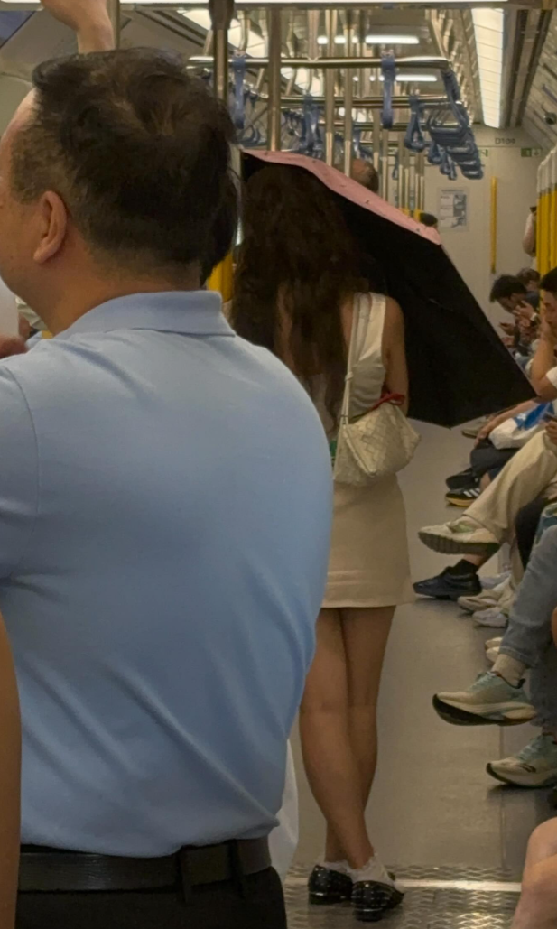 有女網民近日在Threads上傳影片和照片,可見一名長頭髮、身穿無袖連身短裙的女乘客乘搭港鐵時,於車廂打開縮骨遮擋着自己正前方,未能看到其容貌