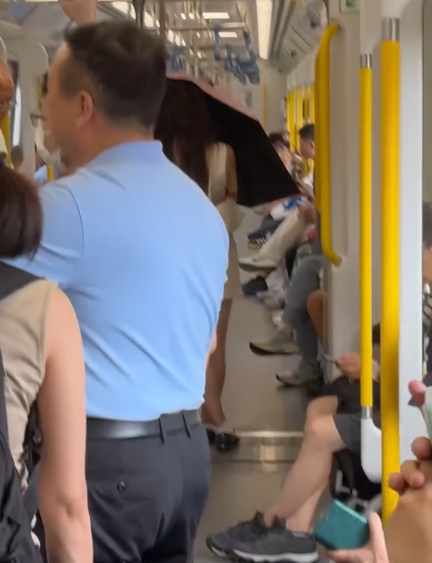有女網民近日在Threads上傳影片和照片,可見一名長頭髮、身穿無袖連身短裙的女乘客乘搭港鐵時,於車廂打開縮骨遮擋着自己正前方,未能看到其容貌