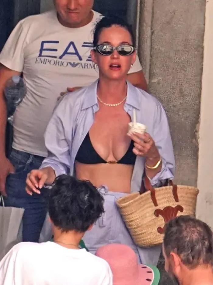 Katy在保鑣護送下離開遊艇。