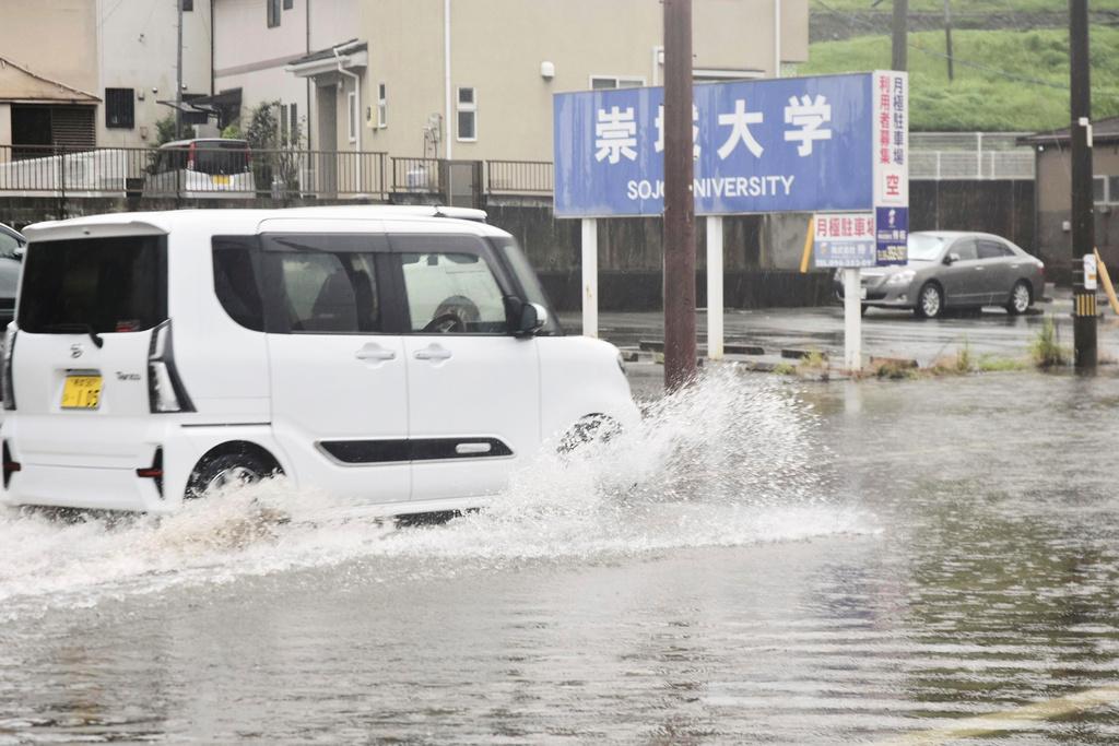 熊本縣有道路被淹浸,汽車涉水前行。(美聯社)