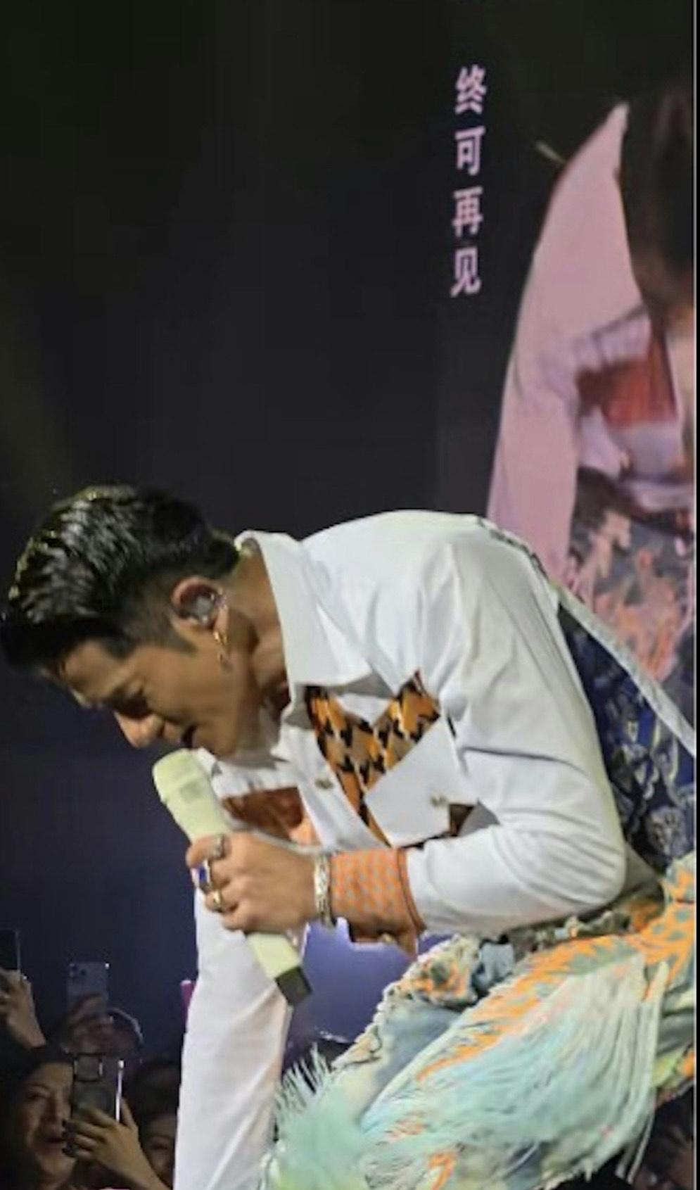 郭富城俯身拾起粉絲的毛巾,並用來抹汗。