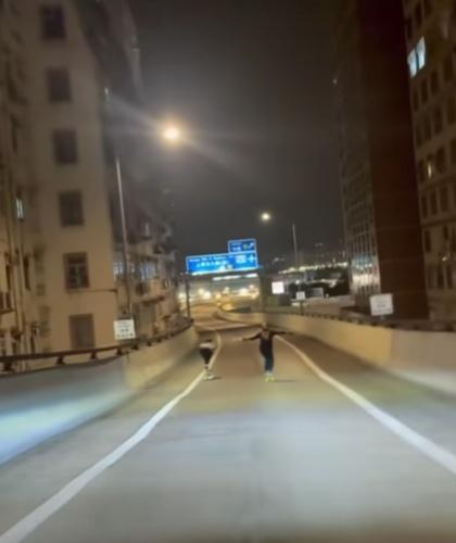 兩名滑板男雙手張開保持平衡,風馳電掣,掟彎時蹲下降低重心。(FB/車cam L(香港群組))