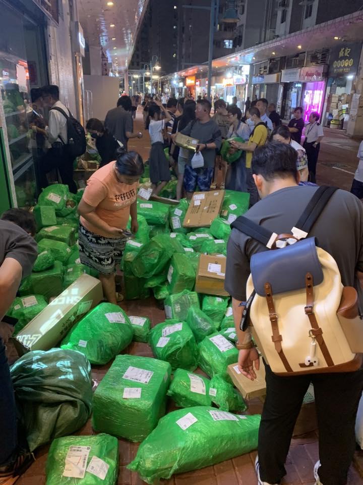 屯門龍門居地下一間自提點外堆滿數以百計、來自拼多多的綠色包裹,形成一片「綠色海洋」,大批街坊下班後在自提點外自行「尋寶」,場面混亂。(龍門居消息交流FB)