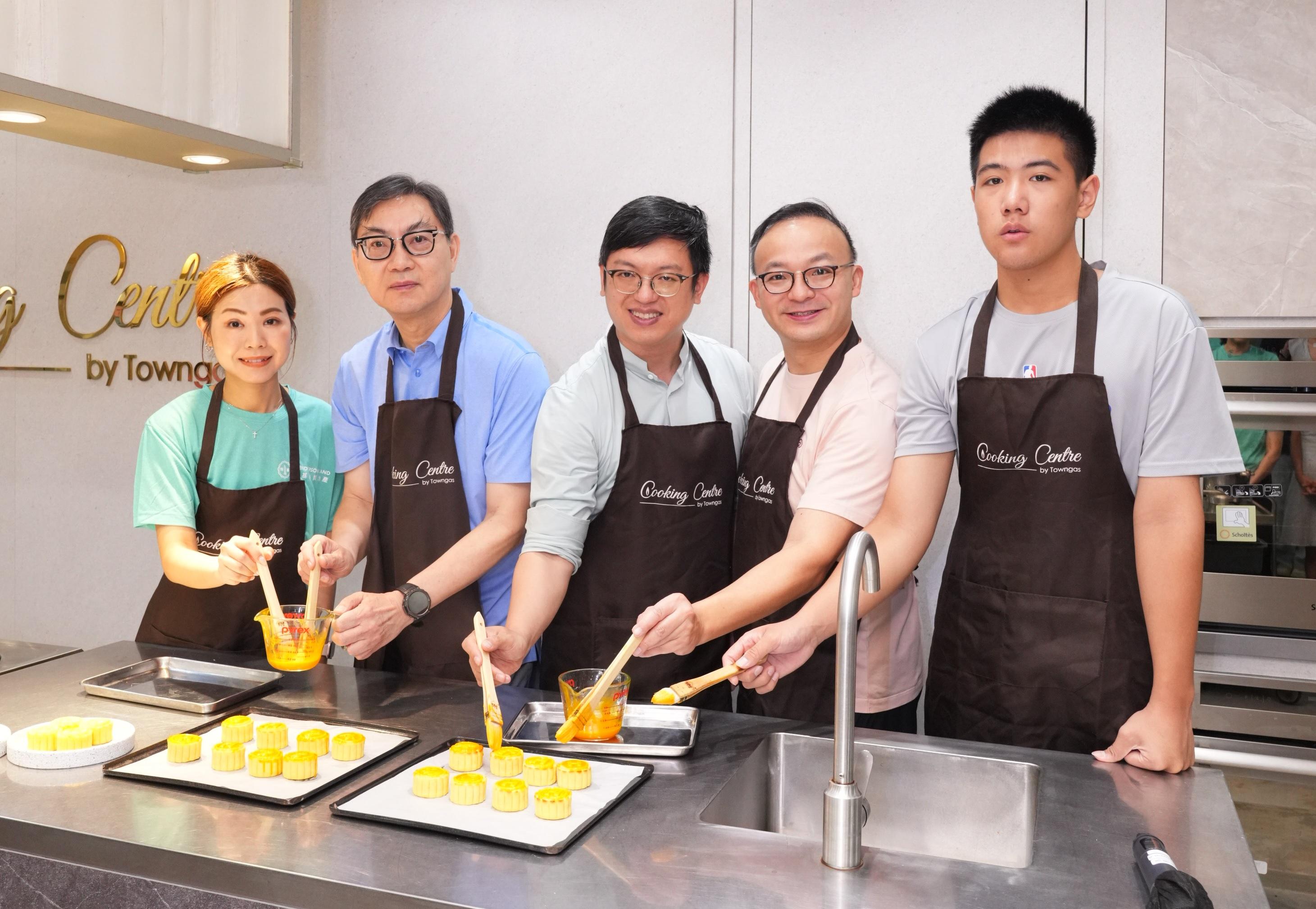 勞福局副局長何啟明先生(中),聯同恒基地產執行董事黃浩明先生(左二)與參與義工及「共創明『Teen』計劃」參加者,一同製作愛心奶黃月餅。(恒地提供)