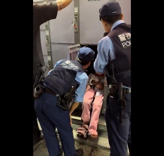 年輕女子抱著小熊維尼公仔睡在儲物櫃裡,警員把她喚醒。(互聯網)