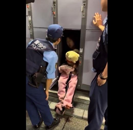 年輕女子抱著小熊維尼公仔睡在儲物櫃裡,警員把她喚醒。(互聯網)