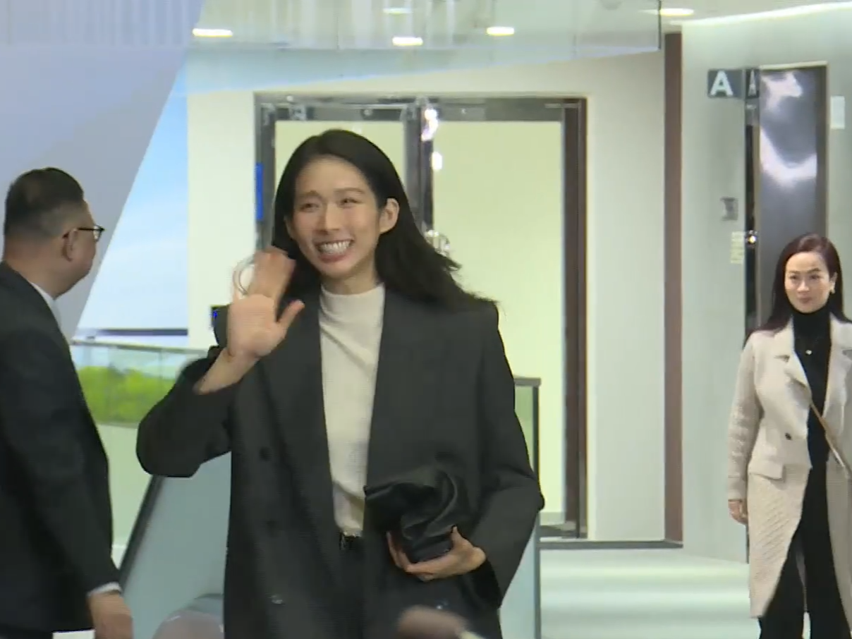 旅遊界候任議員江旻憓入場時,向傳媒微笑兼揮手。(有線新聞截圖)