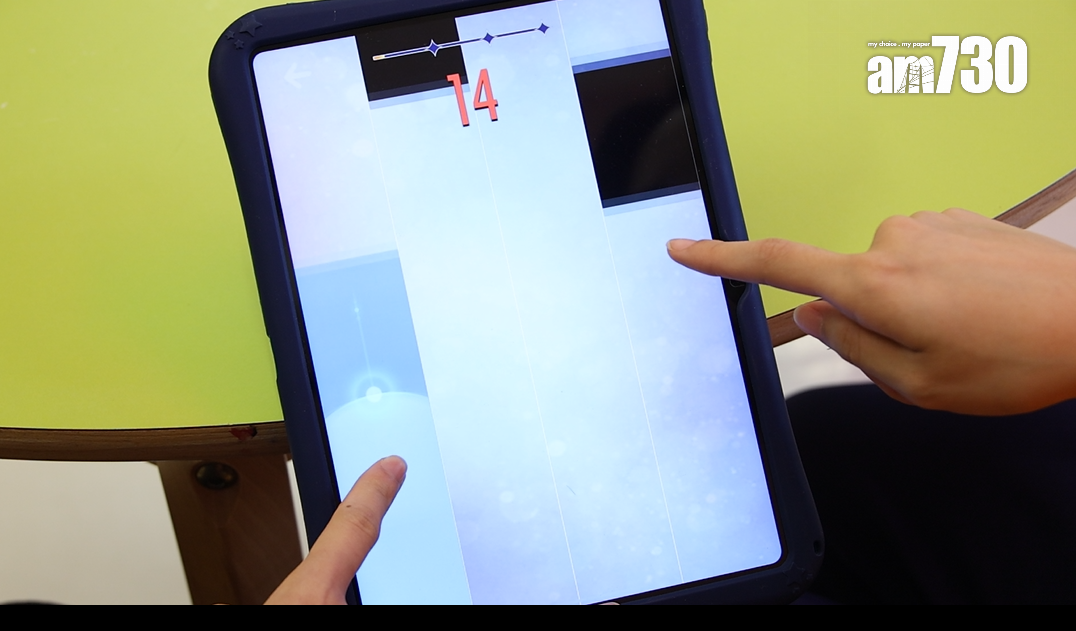 Patience與小朋友 「合體」,各自伸出1隻手玩遊戲,舒緩抽血痛楚。(林俊源攝)