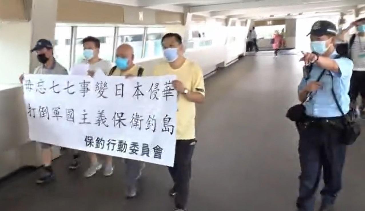 數名保釣行動成員手持橫額，抗議日本當年侵華。(新聞截圖)