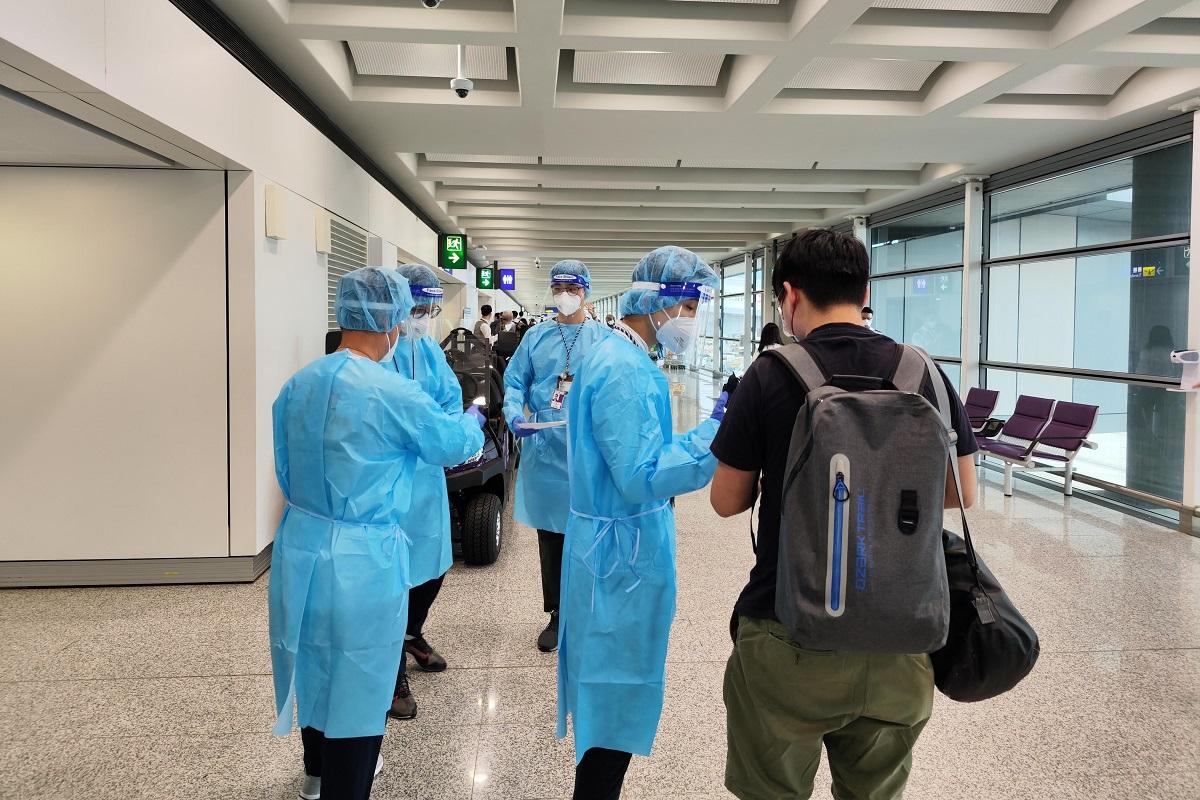 被誘騙到東南亞的求助市民(右一)，安全抵港後獲穿上防護裝備的入境處人員協助。(政府新聞處)