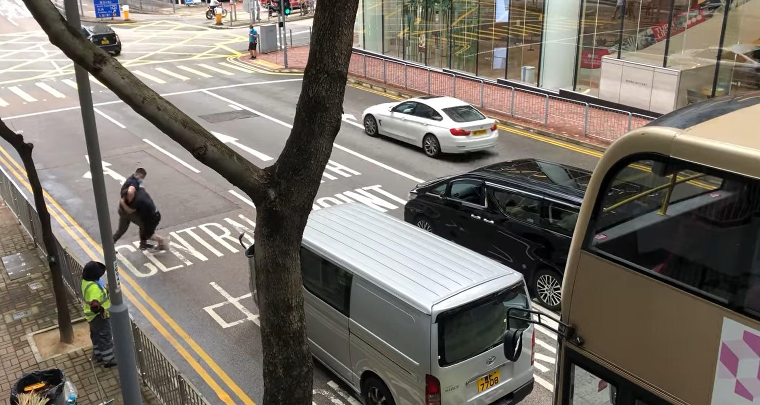 兩名男子在警察總部外打鬥。(網上影片截圖)