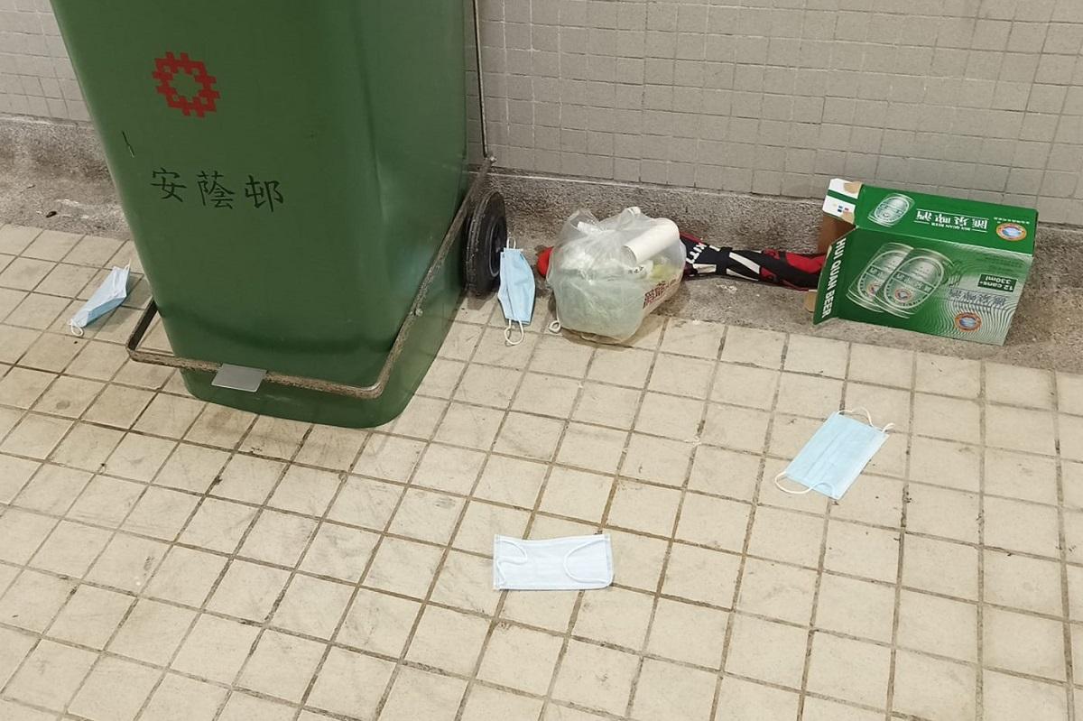 由街坊相片可見大堂的垃圾桶旁，有多個口罩被丟棄在地上。(網民Milk Lin圖片@FB群組「安蔭邨」)
