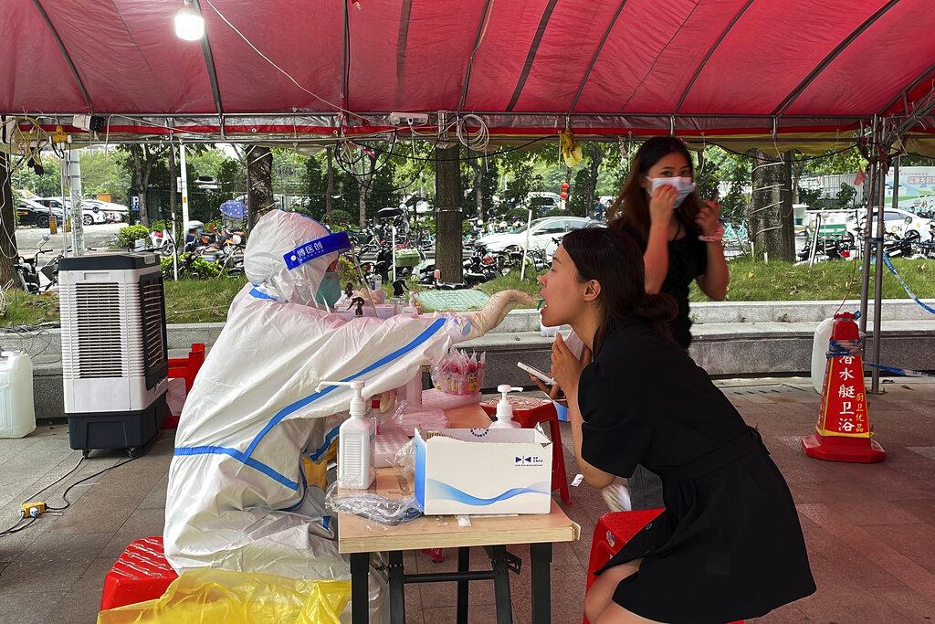 內地疫情擴大，過去一日增至逾2.7萬宗本土病例。圖為有廣東居民接受採樣檢測。(美聯社)