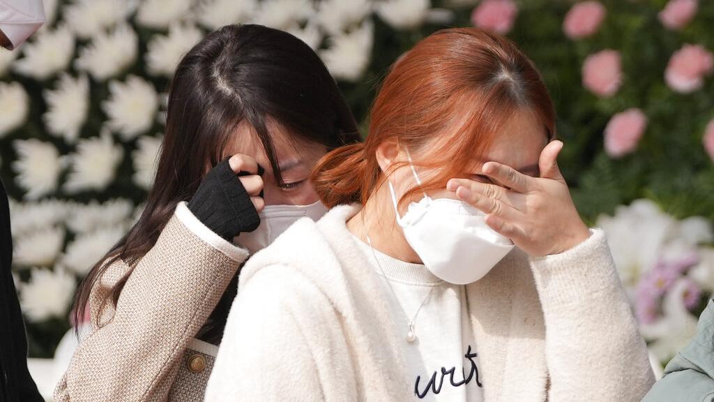 兩名到首爾臨時靈堂致祭的女子，悲痛落淚。(美聯社)
