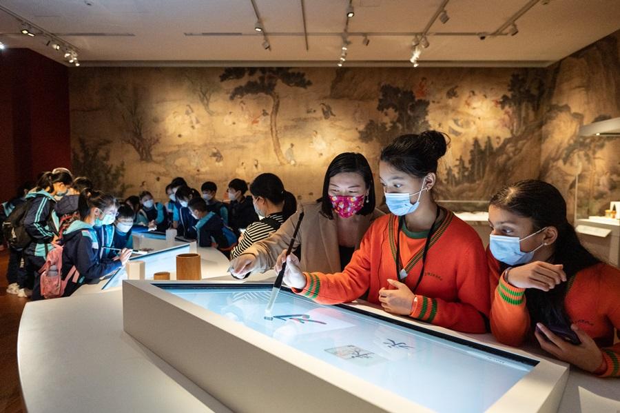 立法會議員林琳教導少數族裔學生如何執毛筆及書寫。