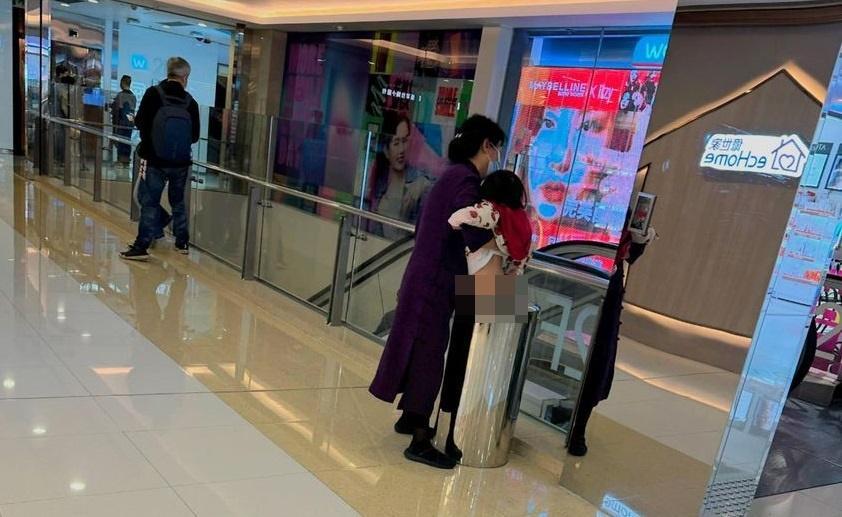 屯門大媽抱起小孩在商場垃圾桶便溺。(真•屯門友fb圖)