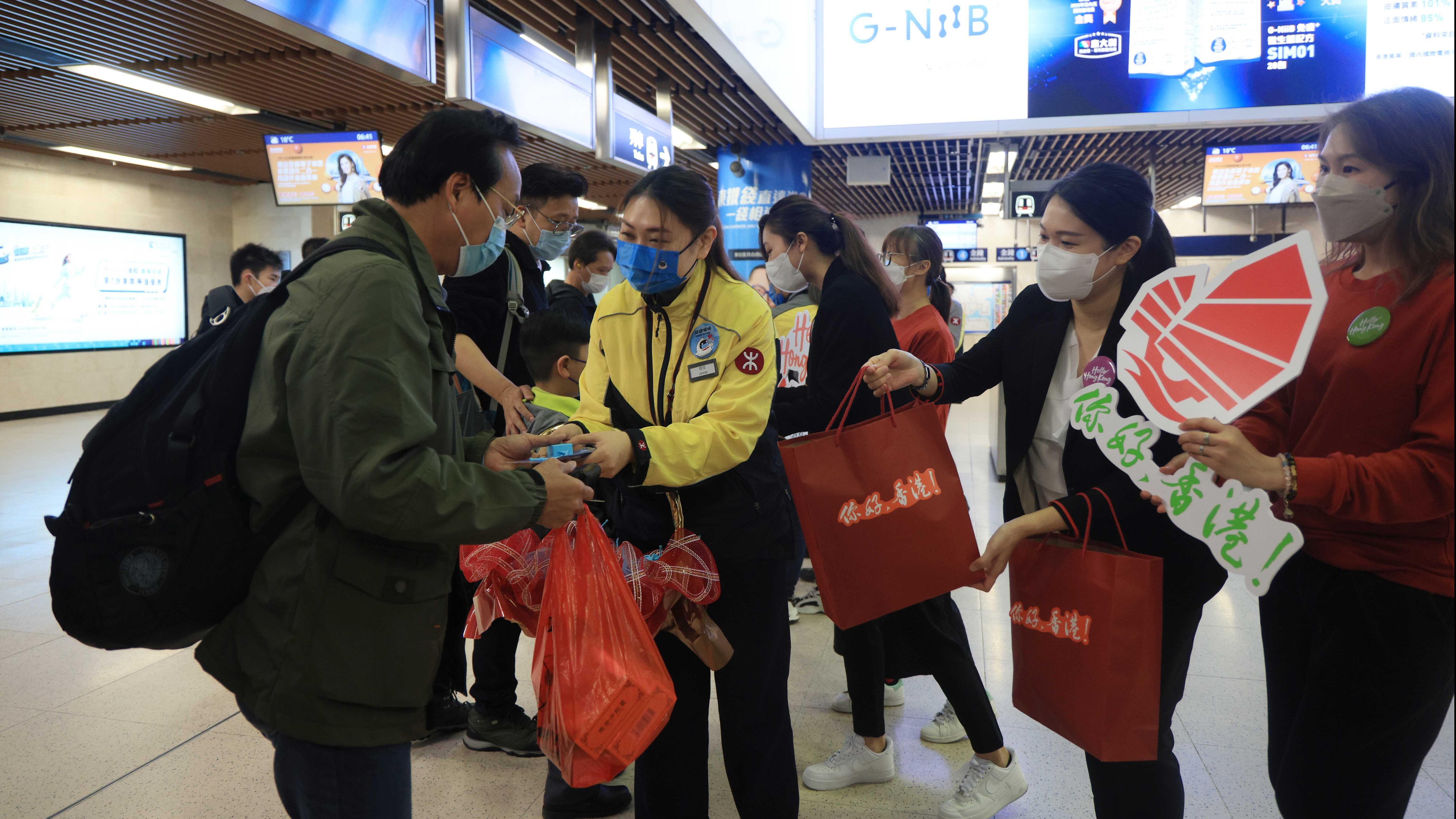 2月6日，大批旅客從羅湖口岸過境前往香港，港鐵羅湖站職員準備了禮物歡迎旅客入境。當日起，香港與內地全面通關，羅湖口岸時隔三年重開。(中通社)
