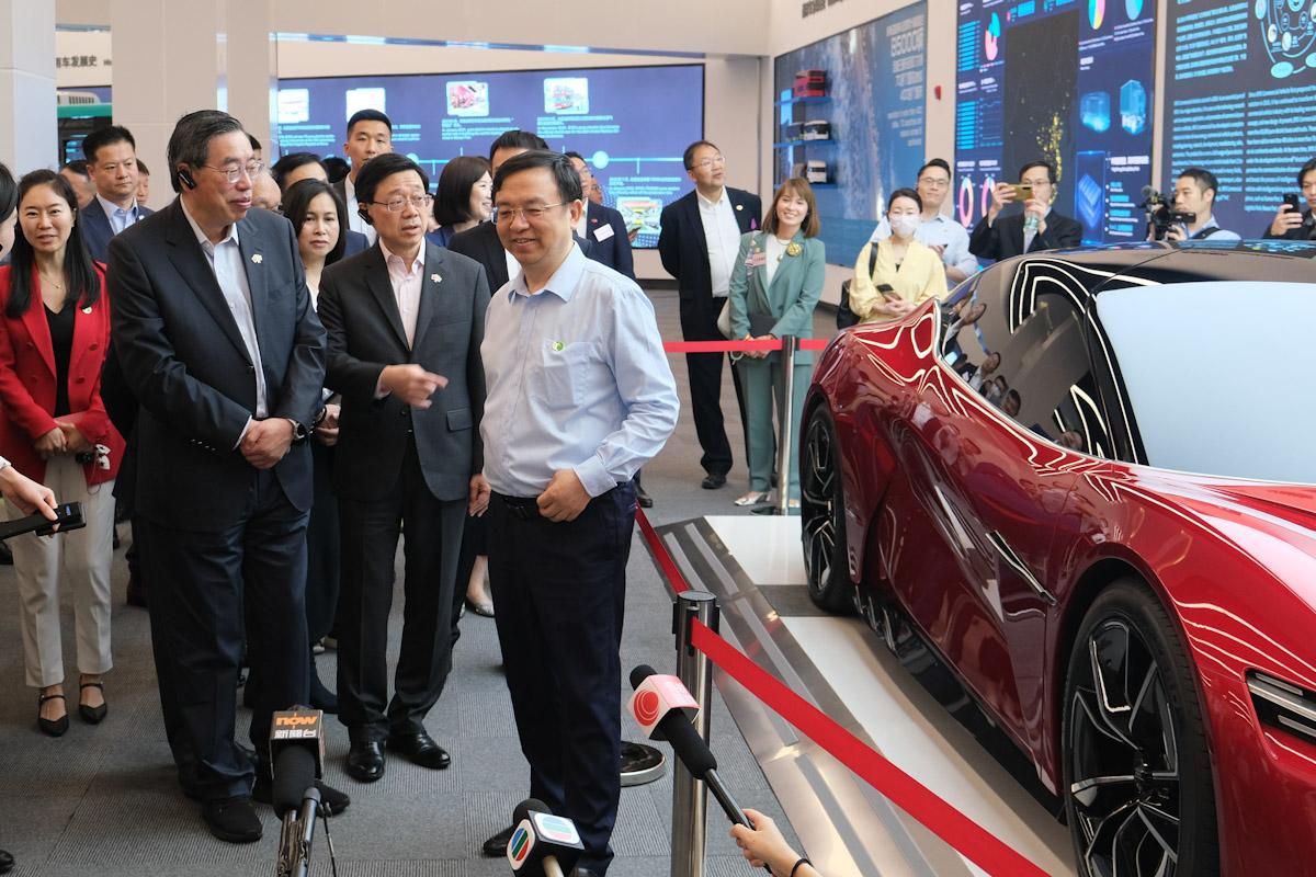 李家超(前排中)聽取王傳福(前排右)介紹比亞迪汽車基地。(羅庸軒攝)