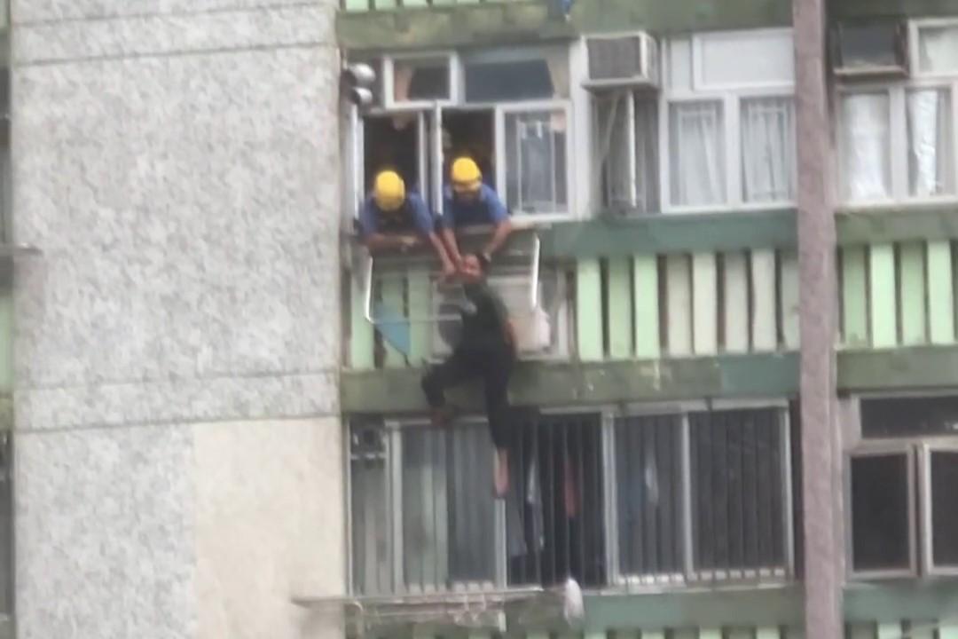 順天邨有女子危坐外牆晾衫架，街坊直擊消防員合力救人過程。(網上影片截圖)