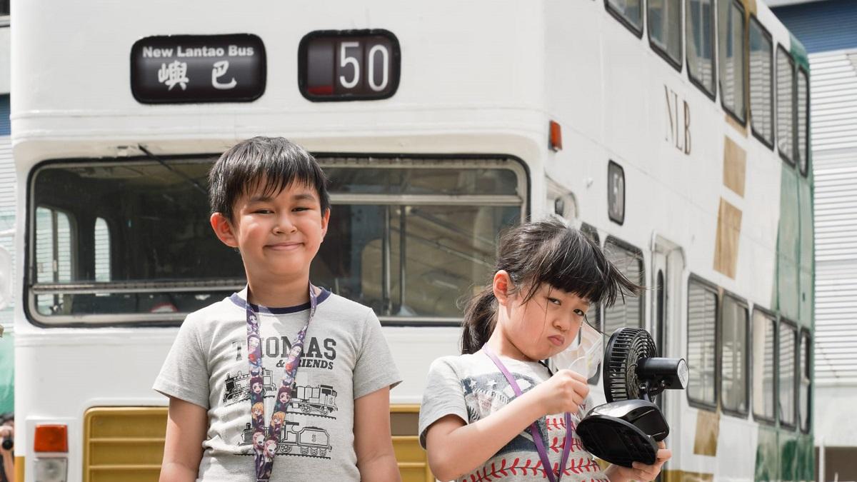 有在場參觀退役巴士的小朋友雖然手持電風扇消暑，但在酷熱天氣下都略顯疲態。(李睿哲攝)