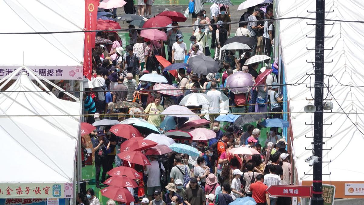 今日是六四事件34周年，維多利亞公園正舉行「家鄉市集嘉年華」，不少市民烈日當空下要撐傘遮蔭。(陳奕釗攝)