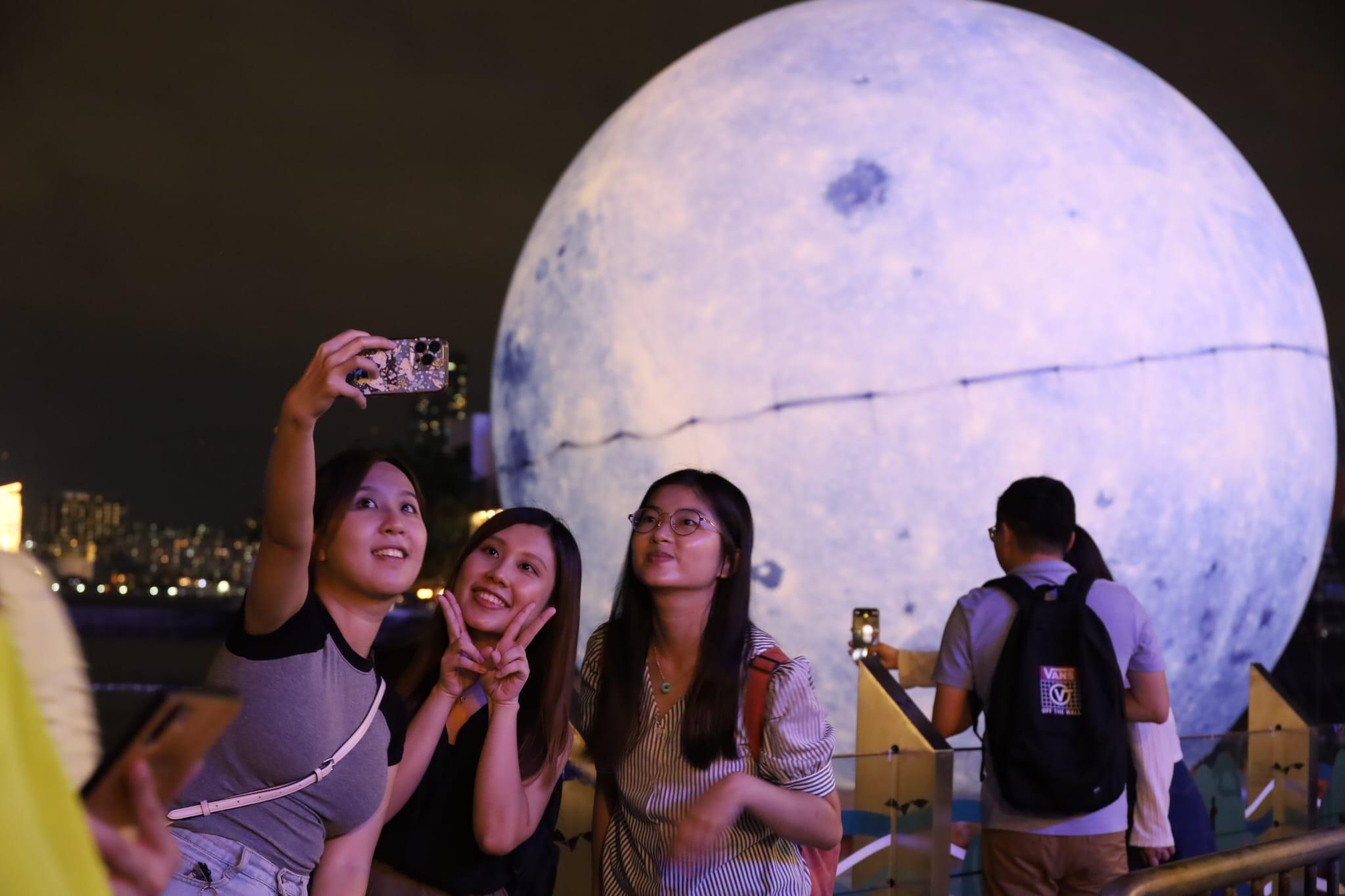灣仔海濱藝遊坊晚上人流不俗 市民與大型月亮打卡迎月 (鍾式明攝)