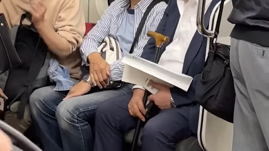 老翁在車廂上向對面的一對父母責罵。(影片截圖)