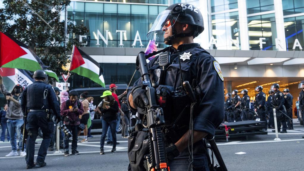 民眾於APEC峰會期間示威，三藩市警員持槍戒備。(美聯社)