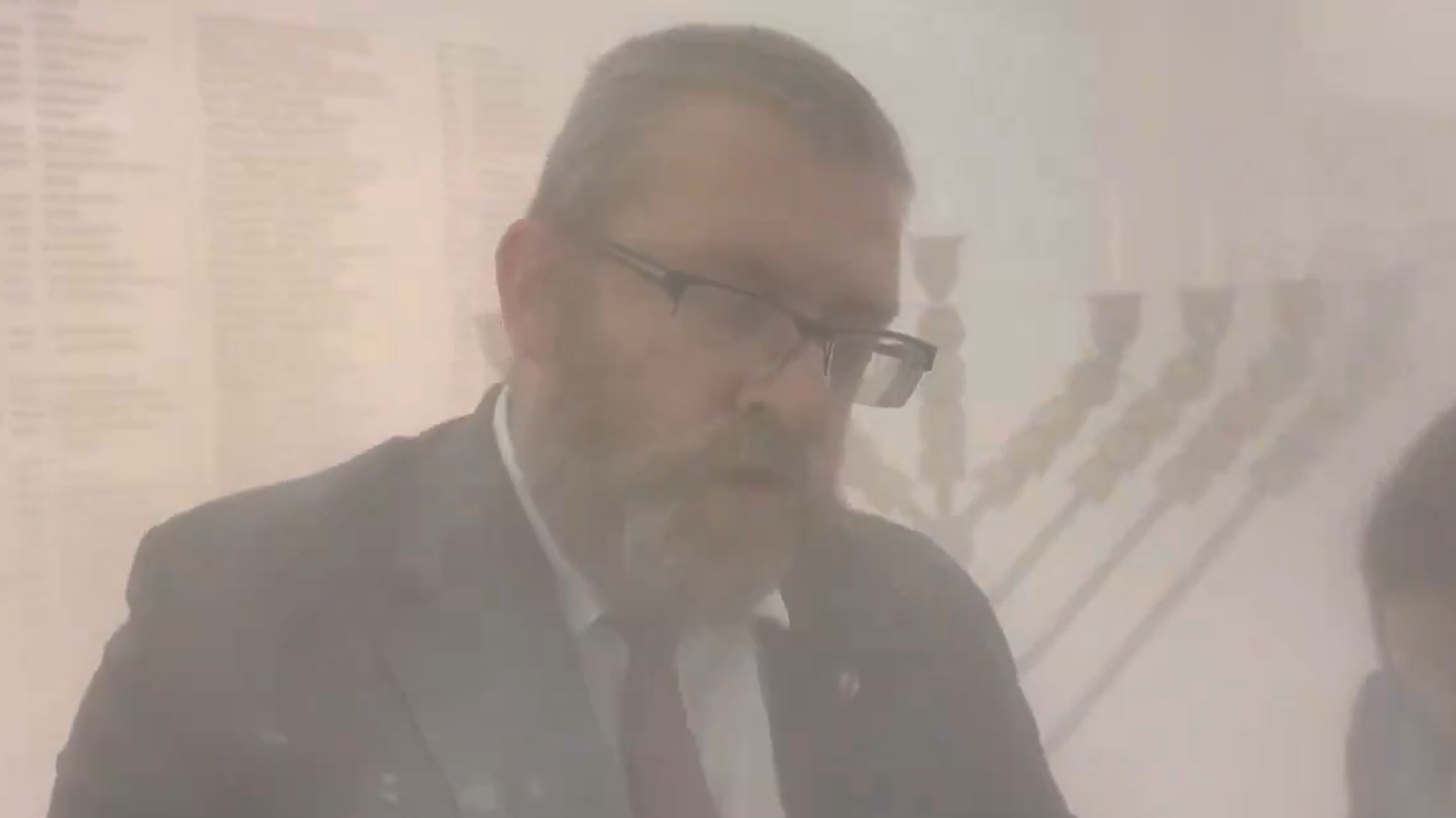 波蘭國會議員布勞恩用滅火筒撲熄蠟燭後，周圍佈滿粉末。(影片截圖)