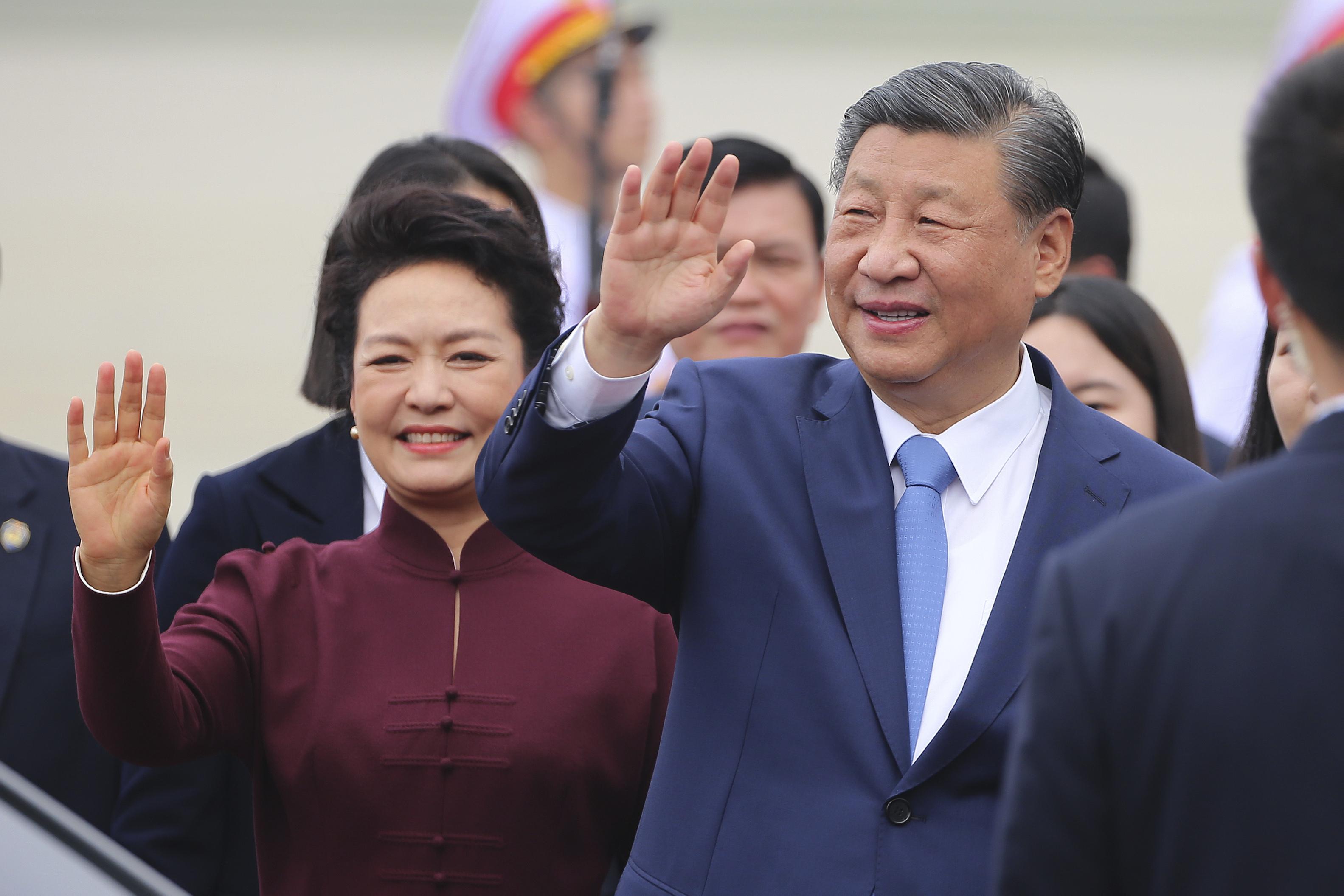 習近平與夫人彭麗媛中午抵達越南河內，向現場人士揮手。(美聯社)