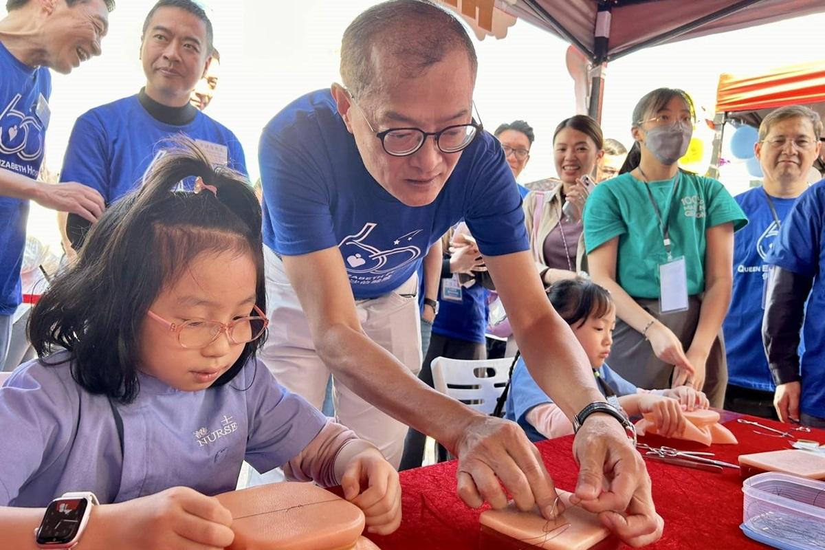 盧寵茂(左三)在「社區健康嘉年華」與小朋友玩攤位遊戲。(醫務衞生局FB)