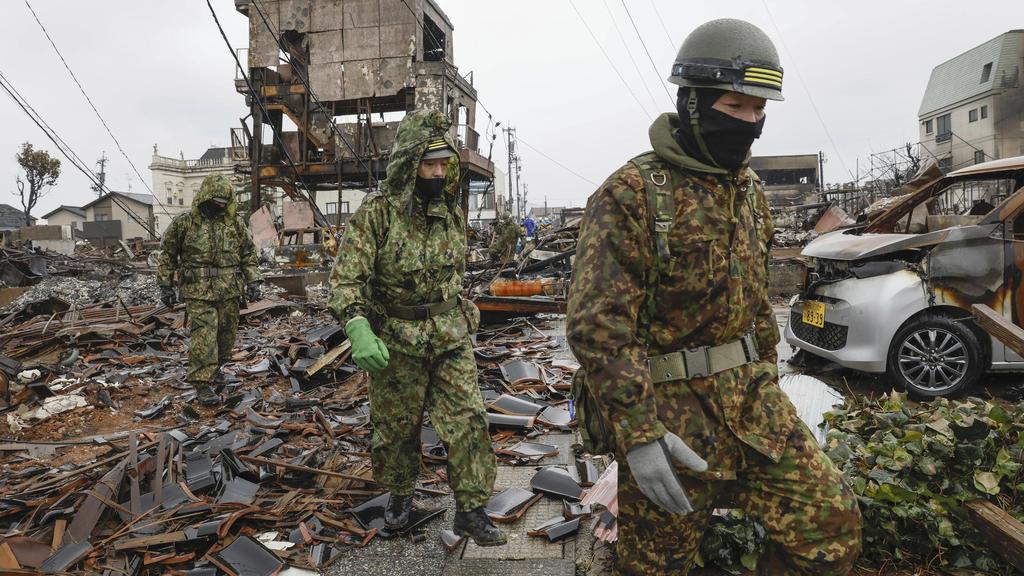 大批人員在大火焚毀的輪島市搜索。(美聯社)