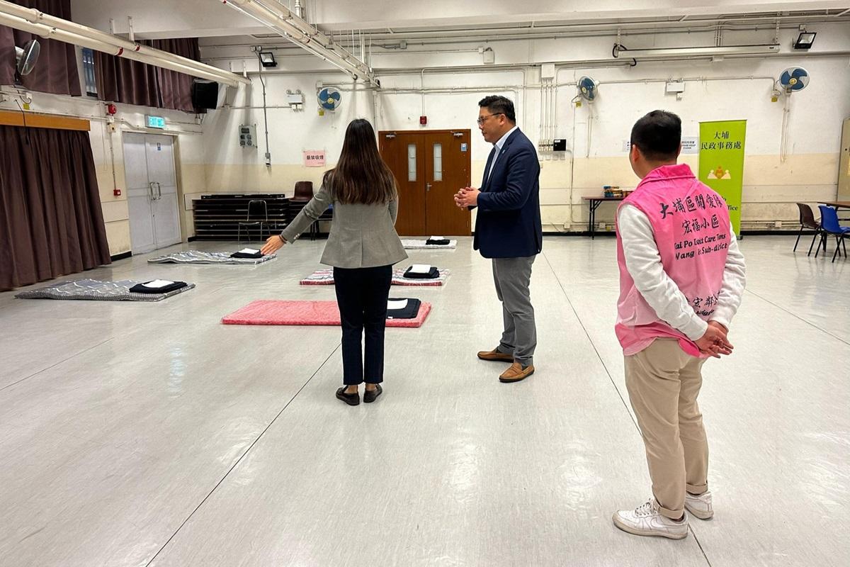 梁宏正(中)到大埔社區中心了解避寒中心運作安排。(民政及青年事務局FB)