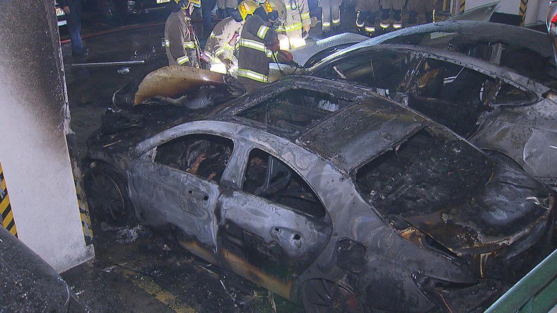 黃大仙盈福苑停車場3樓一輛平治私家車突然起火，波及停泊旁邊的兩輛Tesla電動車及七人車。(無綫新聞截圖)