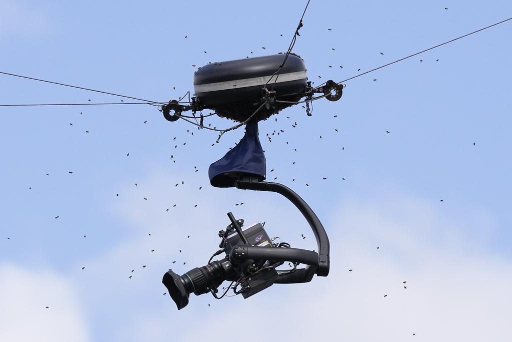 一堆蜜蜂纏擾着一台攝錄機令比賽無法繼續。(美聯社)