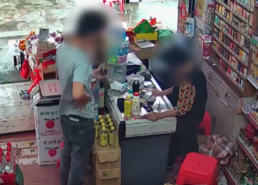 現場響起「掃碼支付成功」的音效，男子將付款頁面讓老婦查看，對方將其選購好的商品裝袋，男子接過後離開。（影片截圖）