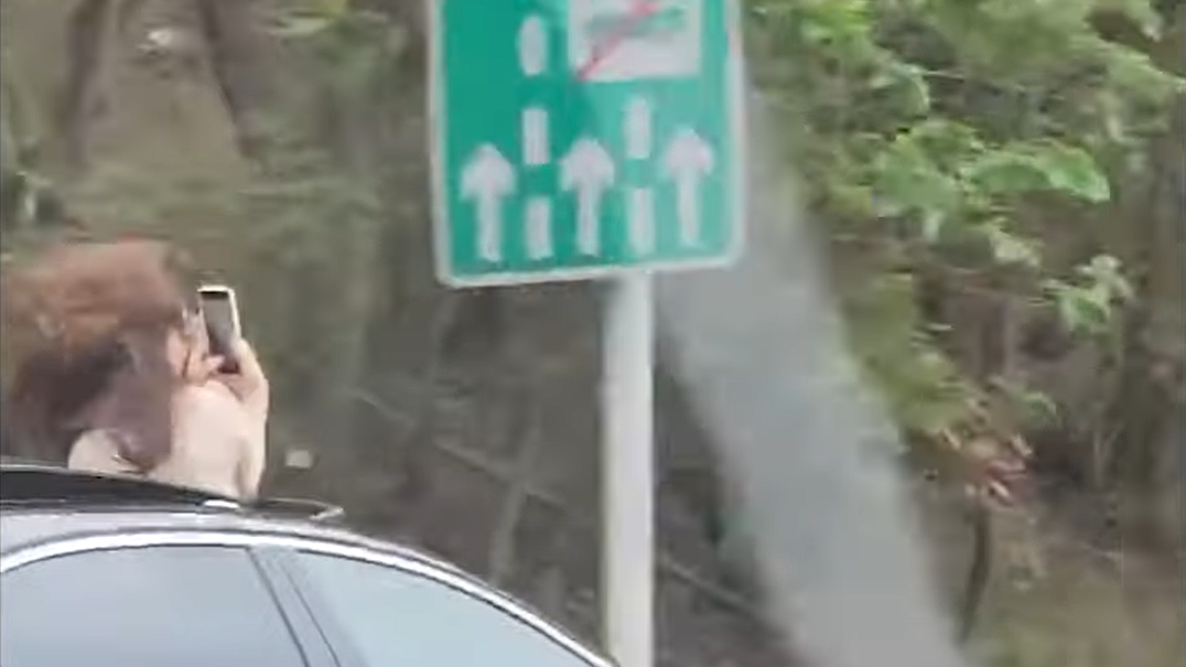 女乘客打開車窗拍片。(影片截圖)