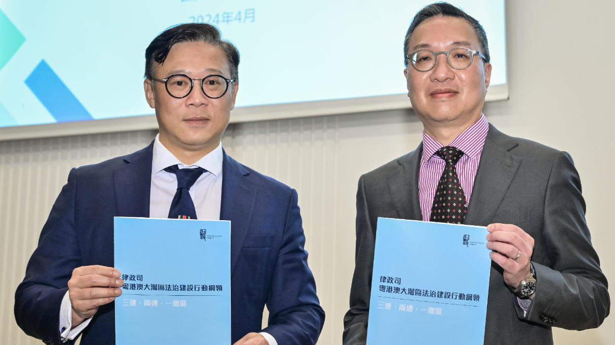律政司司長林定國資深大律師（右）和律政司副司長張國鈞（左）手持新發布的《行動綱領》。政府新聞公報圖片