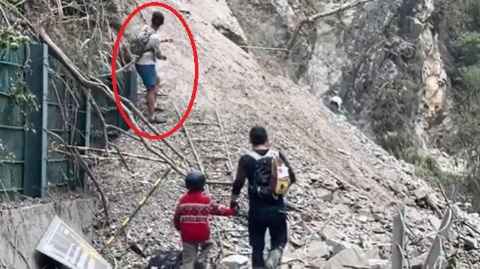 Dimitris Belbas捉緊繩索協助警員帶走受困小孩。(互聯網)