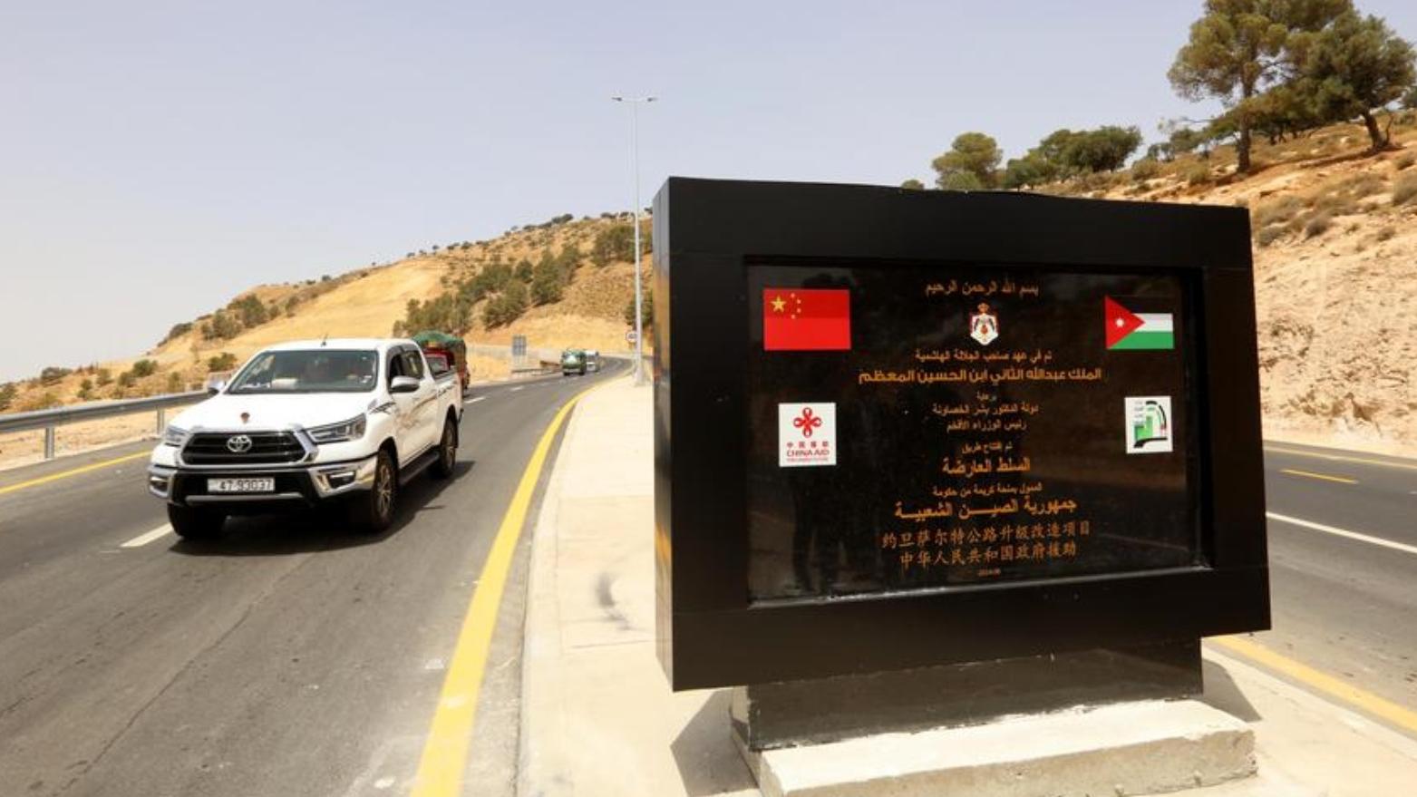 在約旦薩爾特市，一輛汽車經過薩爾特公路旁設立的工程紀念碑。（新華社）