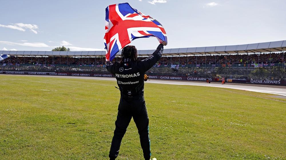 歷史性9次贏得英國站，咸美頓高舉國旗。(路透社)