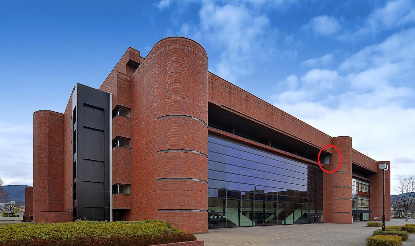 日本長野縣縣民文化會館高樓外牆，憑空出現一道鐵門(紅圈示)，令人不解。(互聯網)