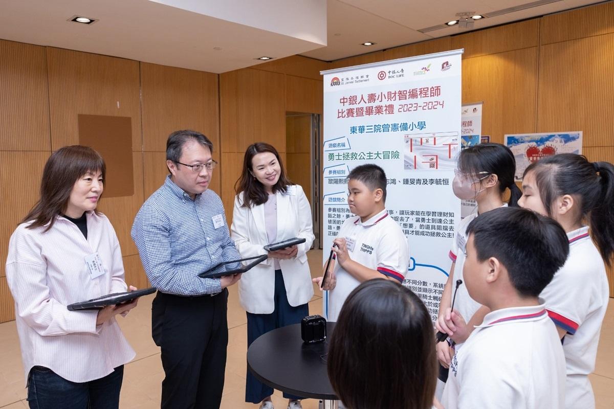 鄧子平(左二)等人聽取同學介紹參賽作品。(大會提供)