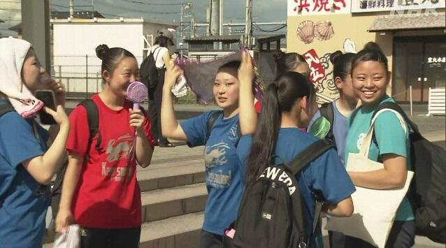 櫪木縣佐野市天氣酷熱，少女在街頭等候，用電風扇降溫。(互聯網)